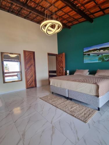 a bedroom with a bed and a green wall at Casa Ferreira Cumbuco in Caucaia