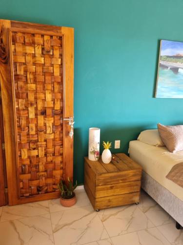 a bedroom with a bed and a wooden door at Casa Ferreira Cumbuco in Caucaia