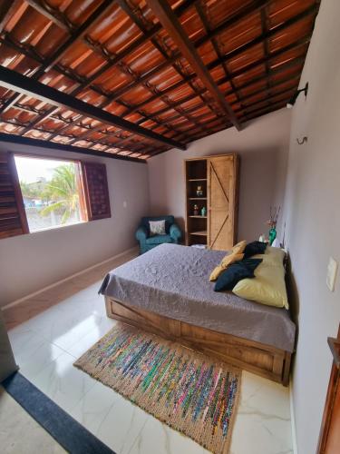 a bedroom with a bed with a wooden ceiling at Casa Ferreira Cumbuco in Caucaia