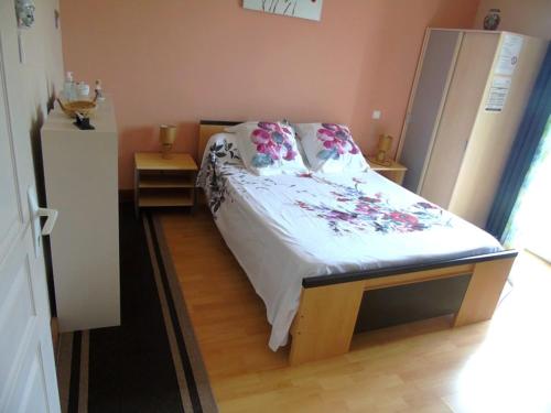 een slaapkamer met een bed met roze bloemen erop bij les Eglantines in Casteljaloux