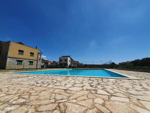 a swimming pool in a villa with a blue sky at Apartman Olive in Tar