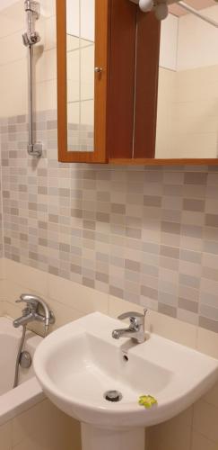 W łazience znajduje się biała umywalka i lustro. w obiekcie Metropolia Apartments w Rydze