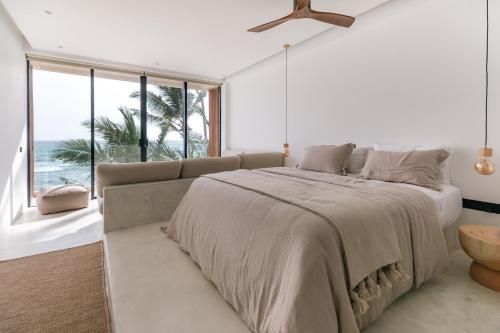 a bedroom with a large bed and a large window at The Hotel in Ahangama