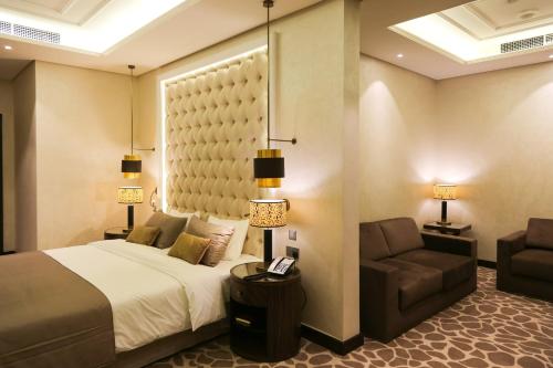 una camera con letto, divano e sedia di The B Premiere Hotel a Doha