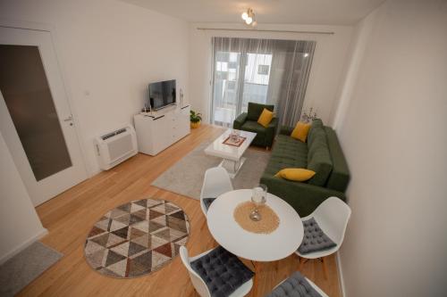 a living room with a green couch and a table at Apartman Kuburica in Trebinje