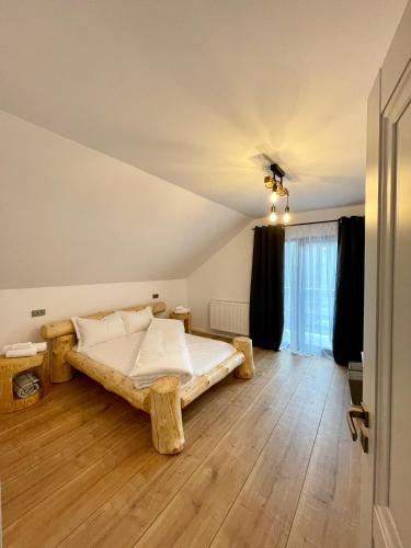 a bedroom with a wooden bed in a room at Hill House SD in Topliţa