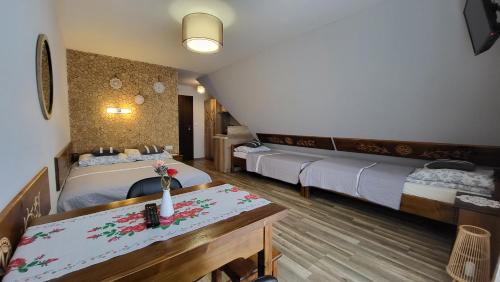 Habitación de hotel con 2 camas y mesa en Wierchowianka en Bukowina Tatrzańska