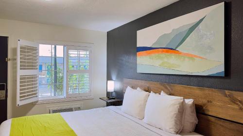 a bedroom with a bed and a painting on the wall at City Center Motel in Medford