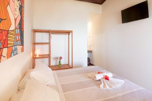 a room with a bed with towels on it at Pousada Enseada Dos Golfinhos in Pipa
