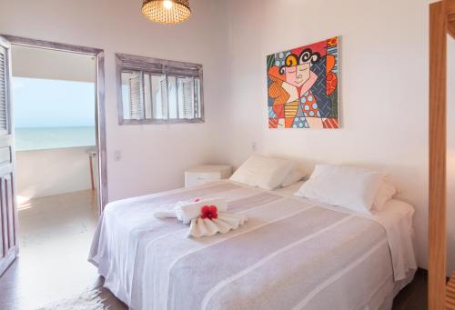 a bedroom with a white bed with a flower on it at Pousada Enseada Dos Golfinhos in Pipa