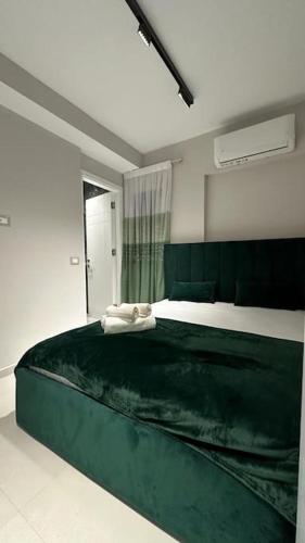um quarto com uma grande cama verde num quarto em Host Apartament Elio em Tirana