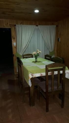 einen Esstisch mit einer Blumenvase darauf in der Unterkunft Cabañas Anny in Linares