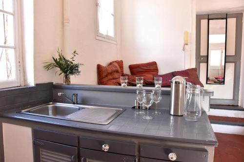kuchnia ze zlewem i kieliszkami do wina na blacie w obiekcie Lovely flat in the heart of the medieval city w Hyères