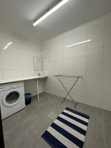 a laundry room with a washing machine and a rug at Vandrarhem Oden in Odensbacken