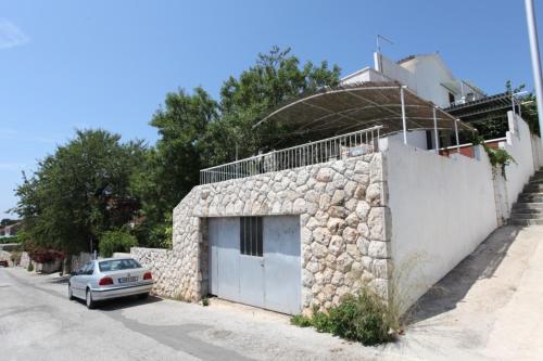 a car parked next to a stone building with a garage at Apartments & Rooms Zlatica Hvar in Hvar