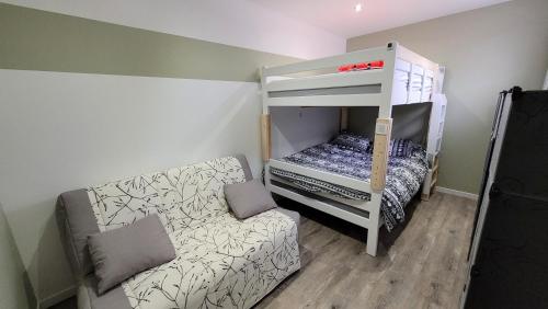 a bedroom with a bunk bed and a couch at Update Location in Lanester