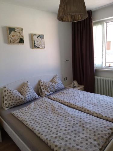 ラヴァローネにあるCasa Giallaのベッドルーム1室(ポルカドットの枕付きのベッド1台付)