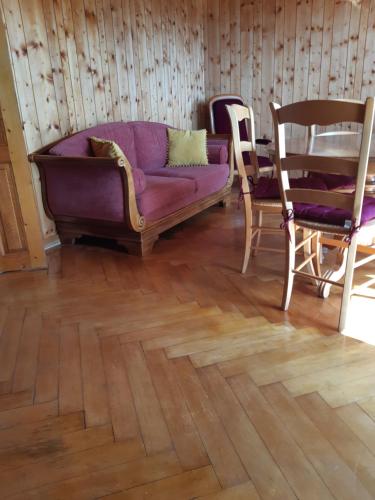 a living room with a purple couch and chairs at La maison horlogère , spas et bain nordique in Les Fontenelles