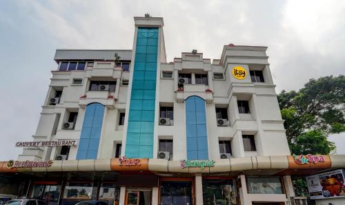 a large white building with a yellow sign on it at Itsy By Treebo - Coastal Grand Sathyam in Fort