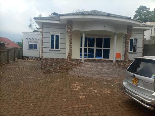 a house with a car parked in front of it at Pearl Furnished Home in Buloba