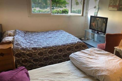 une chambre avec deux lits et une télévision et un lit dans l'établissement Charming studio at the heart of 14 arrondissement, à Paris