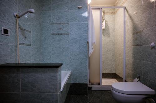a bathroom with a toilet and a glass shower at La Grua House in Castelbuono