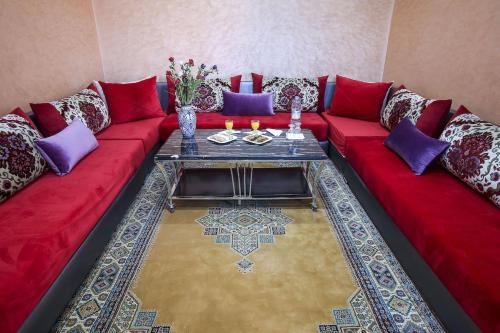 a red couch with purple pillows and a table at HOTEL LA POMME ZAIDA in Zaida