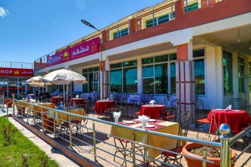 a restaurant with tables and chairs in front of a building at HOTEL LA POMME ZAIDA in Zaida