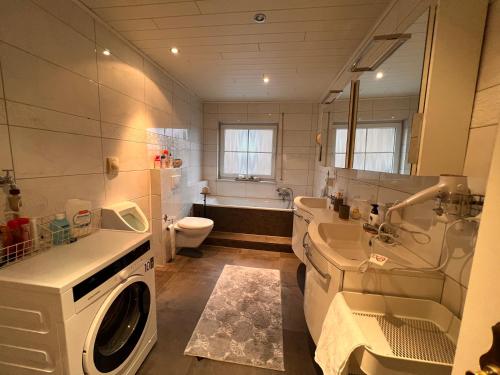 een badkamer met toilet, wastafel en wasmachine bij Ferienwohnung in bester Lage Kassels in Kassel