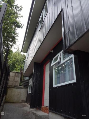 una casa nera con una porta rossa e una finestra di Apartamento por dia a Puerto Montt