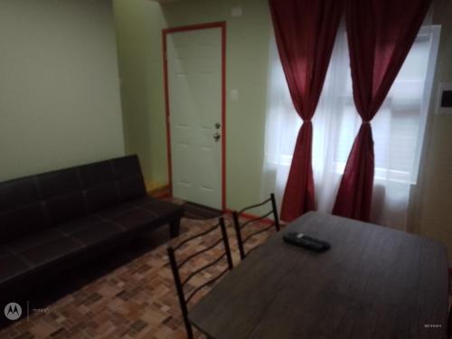 a living room with a black couch and a table at Apartamento por dia in Puerto Montt