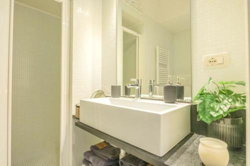 een badkamer met een witte wastafel en een spiegel bij [Penthouse] Piazza San Giacomo in Udine