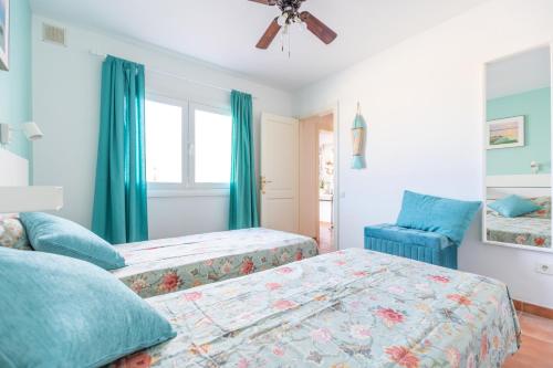 1 dormitorio con 2 camas y silla azul en Private villa with heated pool & terrace see view, en Corralejo