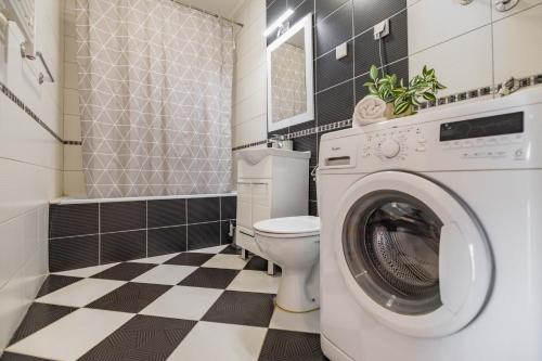 a bathroom with a toilet and a washing machine at Apartment Simpatico in Novi Sad