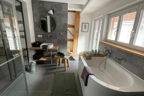y baño con bañera y lavamanos. en Das Schatzgräberhaus im Herzen von Bamberg. en Bamberg