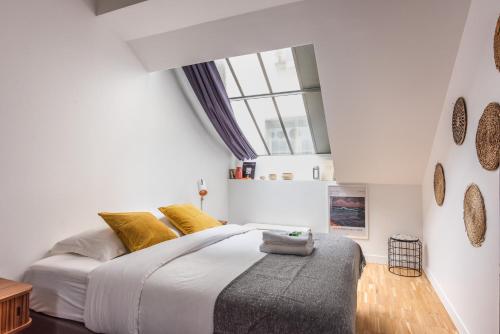 a bedroom with a large bed and a window at Outstanding Architect Loft - Canal St Martin in Paris
