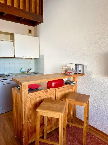 une cuisine avec des comptoirs en bois et un bol rouge dans l'établissement LE MONTAGNARD, à Isola 2000