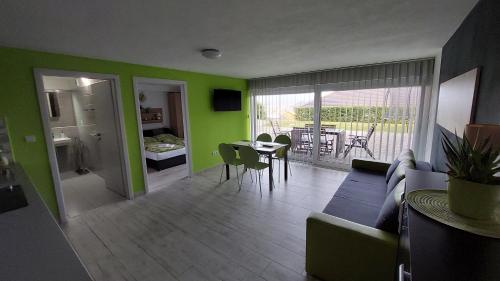 ein Wohnzimmer mit grünen Wänden sowie einem Tisch und Stühlen in der Unterkunft Dream House in Gröbming