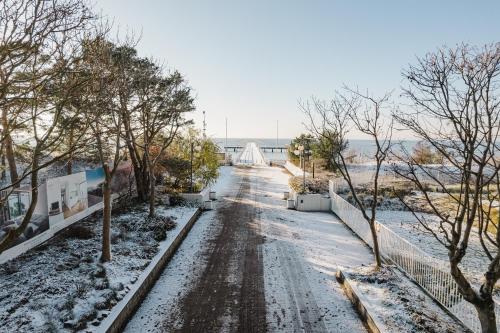 a snow covered road with a bridge in the background at Villa Aqua BlueApart Jurata in Jurata