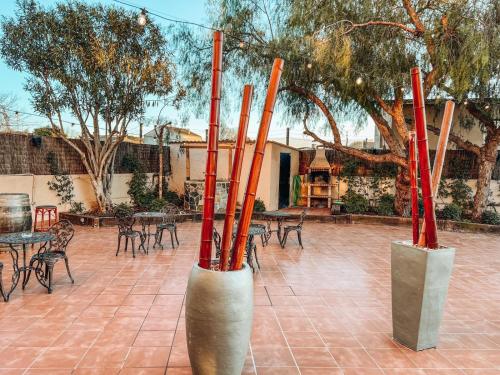 a group of poles in a courtyard with tables and chairs at Hotel H in Granollers
