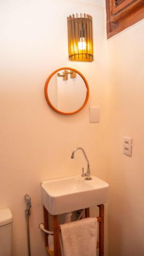a bathroom with a sink and a mirror on the wall at Condomínio Aurora - Suítes in Jericoacoara