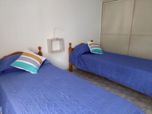 2 camas en una habitación con sábanas azules en Alquiler turístico de casa en San Rafael en San Rafael