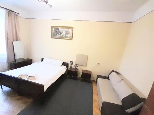 ein Schlafzimmer mit einem Bett und einem Sofa darin in der Unterkunft Apartment near the train station in Lwiw