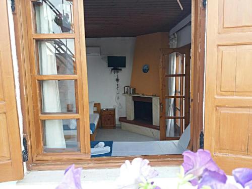 ein Zimmer mit einer offenen Tür und einem Wohnzimmer in der Unterkunft nostalgo in Skiathos-Stadt