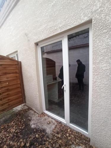 uma porta de vidro deslizante de um edifício com um homem do lado de fora em Joffre thermes em Vichy