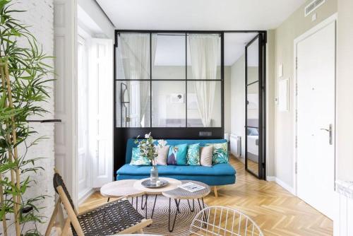 uma sala de estar com um sofá azul e uma mesa em Joffre thermes em Vichy