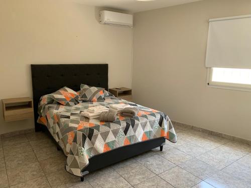 a bedroom with a bed with a colorful comforter at Casa de Ali in Villa Carlos Paz