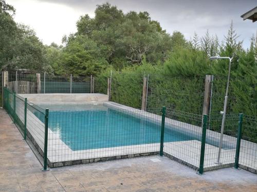 een zwembad met een hek eromheen bij CASA HUGANA in Benalup Casas Viejas