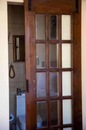 a door to a bathroom with a toilet at Hotel Santa Cruz Punta Zicatela in Puerto Escondido