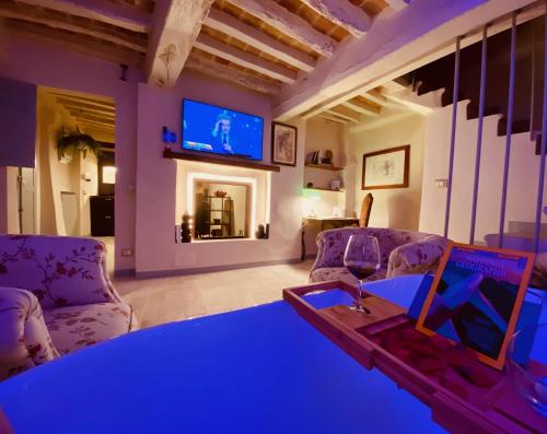 a living room with a couch and a table and a tv at Vermaaten Boutique Suites Diamond in Todi